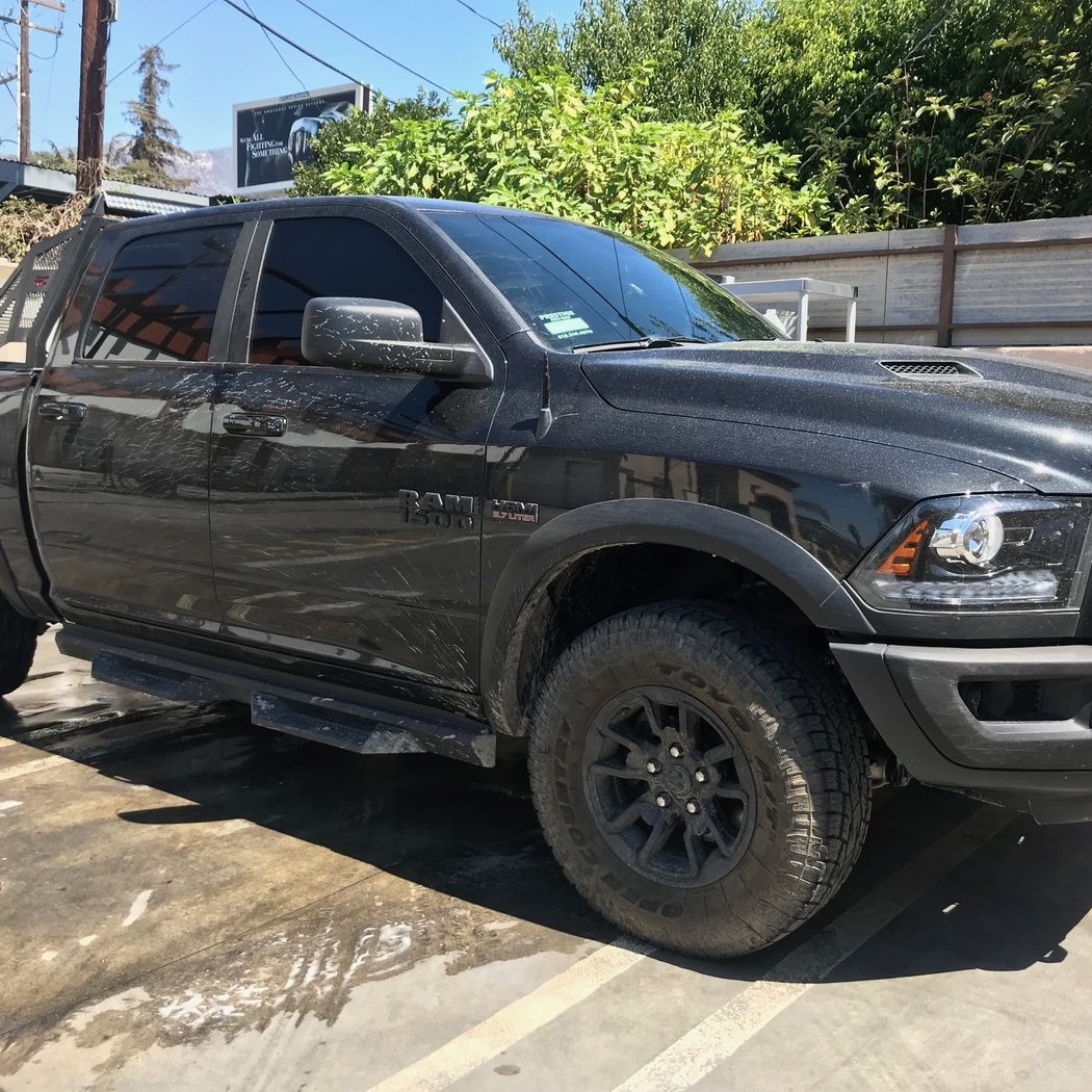 Black Ram 1500 truck mid-wash with foam and water at Fair Oaks Car Wash