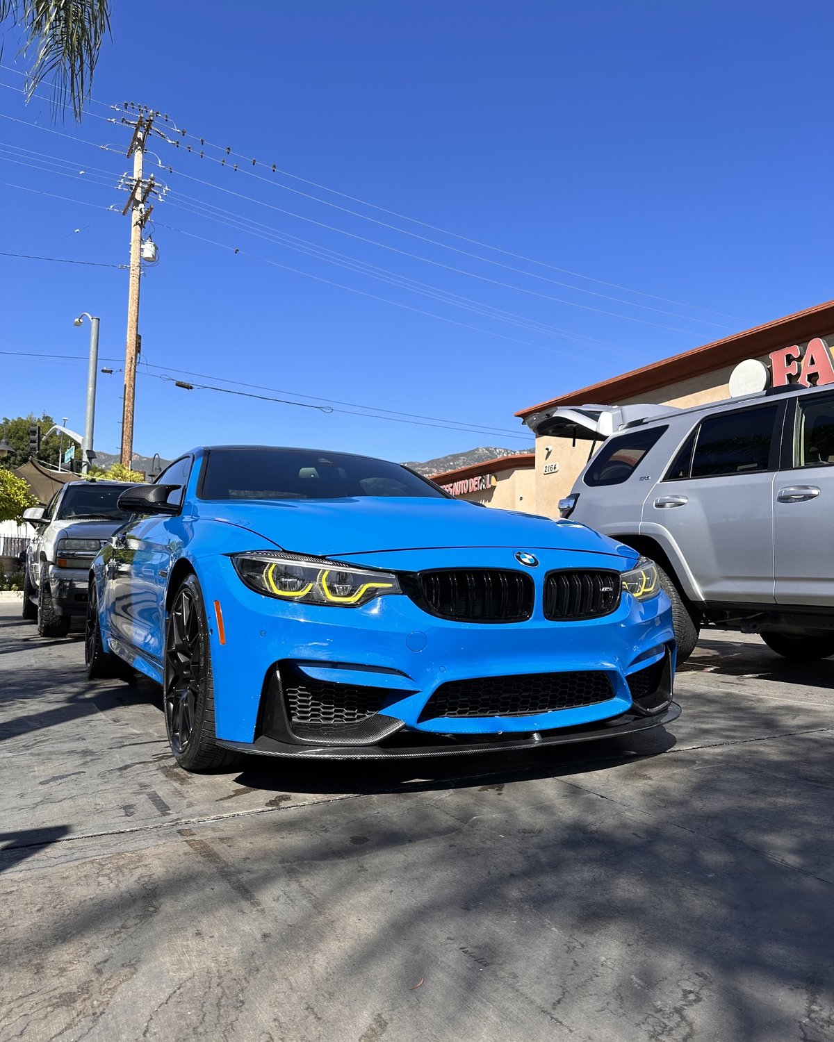 Bright blue BMW M4 with carbon fiber splitter at Fair Oaks Car Wash in Altadena